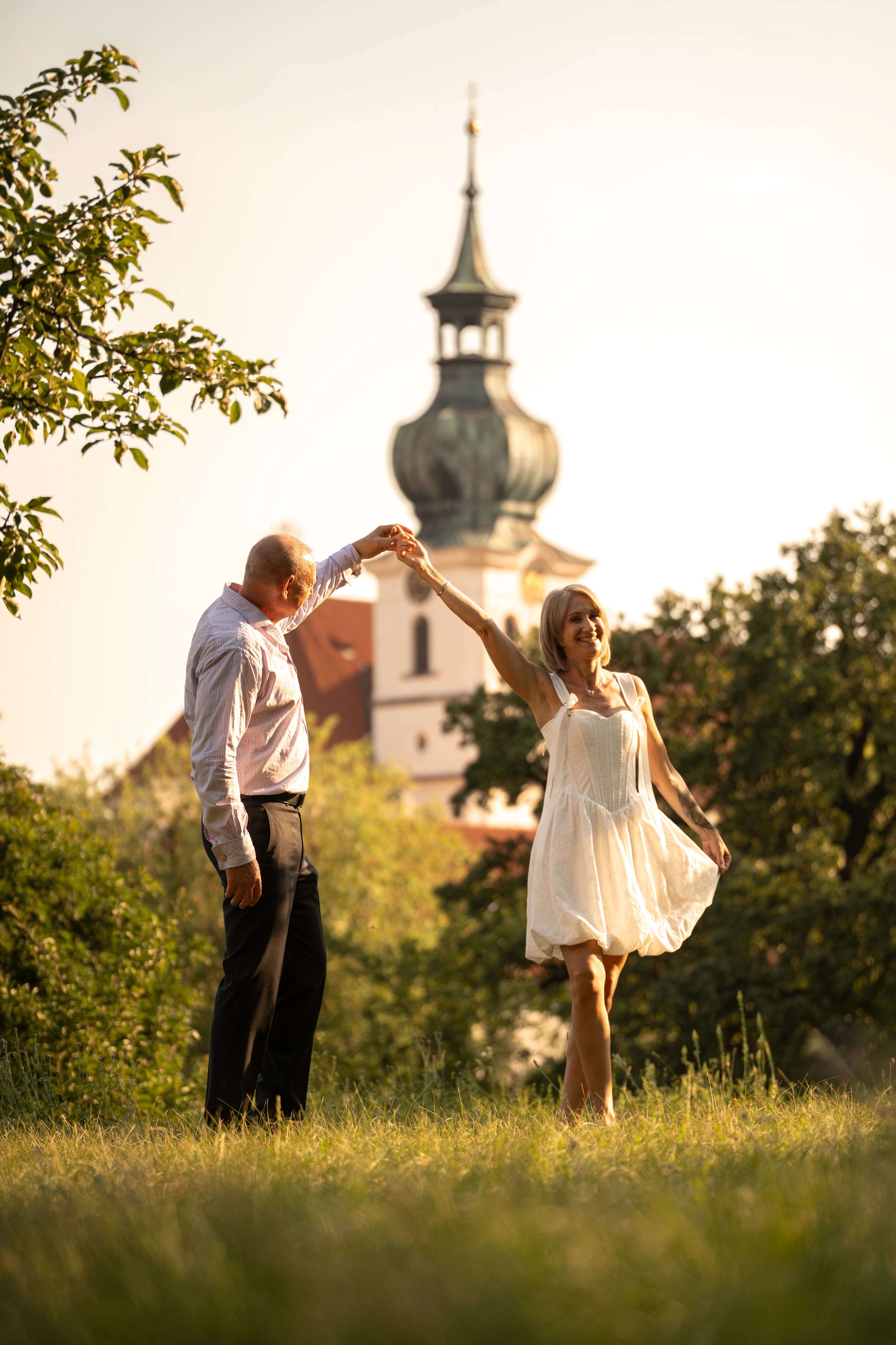 Couple de mariés qui dansent devant le clocher baroque de Prague, photographe de mariage Prague Clément Bayard