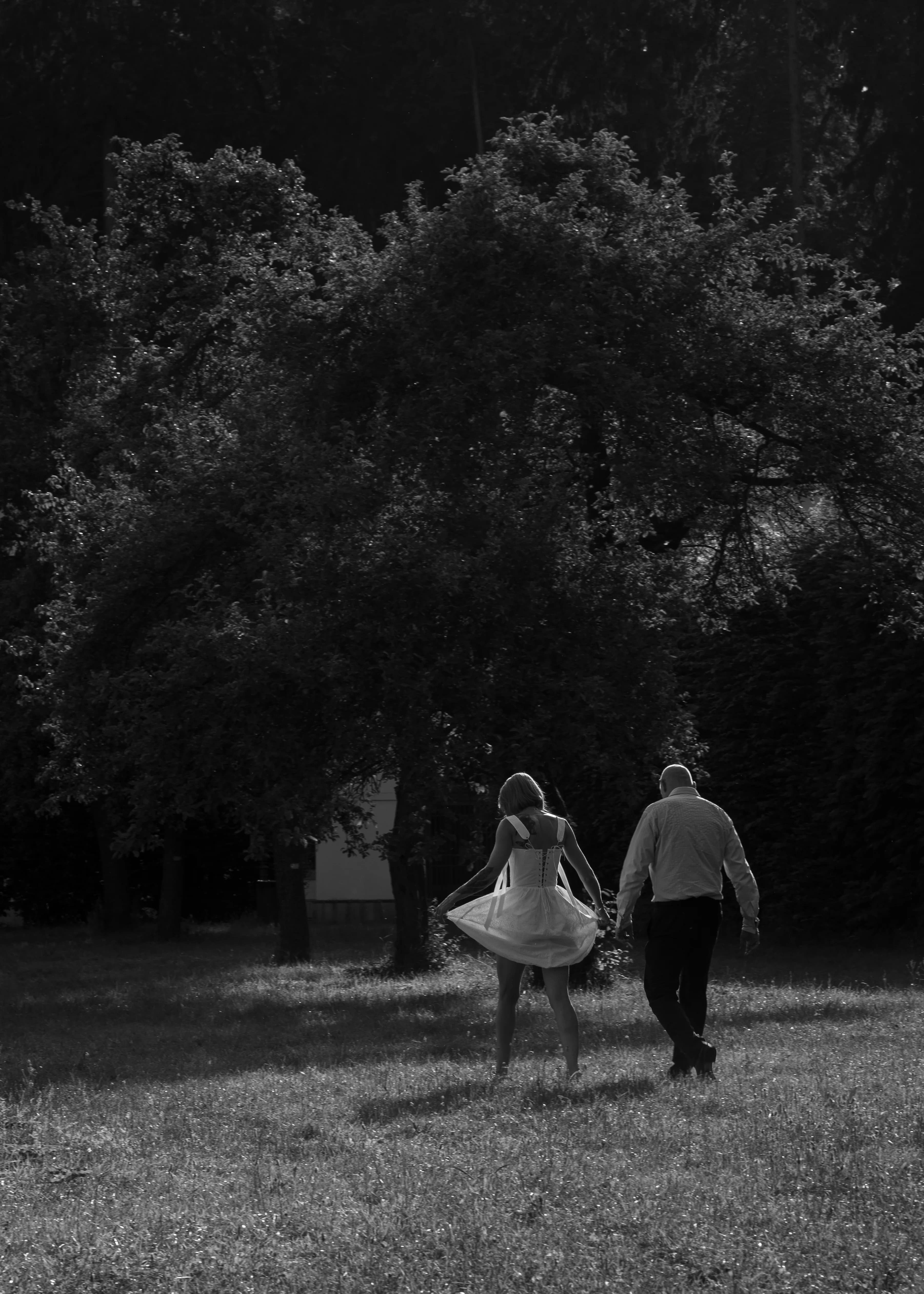 Couple de mariés en noir et blanc marchant dans la verdure de Prague, photographe de mariage Prague Clément Bayard